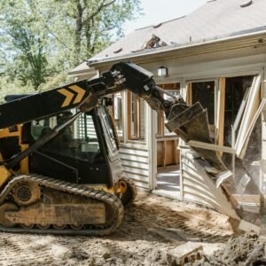 a bulldozer digging dirt in front of a house
